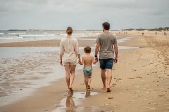 Famille se promenant sur la plage de Capbreton à marée basse, sable mouillé et vagues en arrière-plan